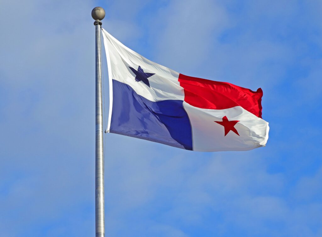 Panama flag waving against a clear blue sky, symbolizing patriotism and national pride.