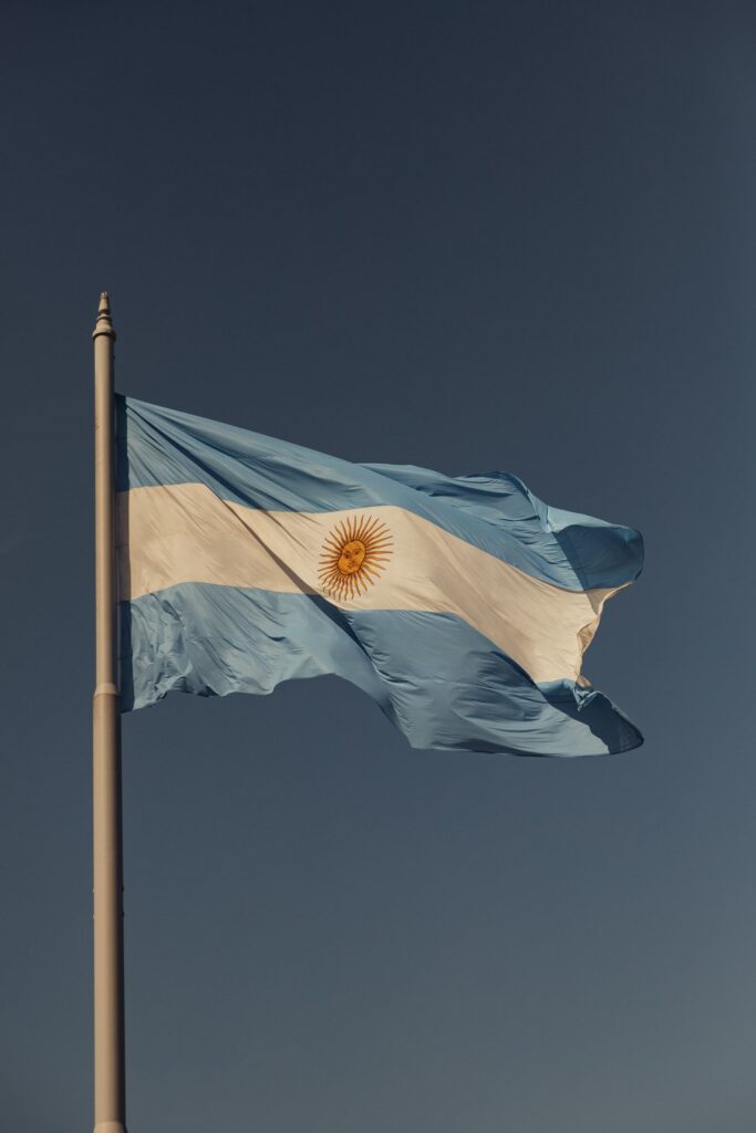 Close-up of an Argentinian flag waving against a clear blue sky, showcasing national pride.